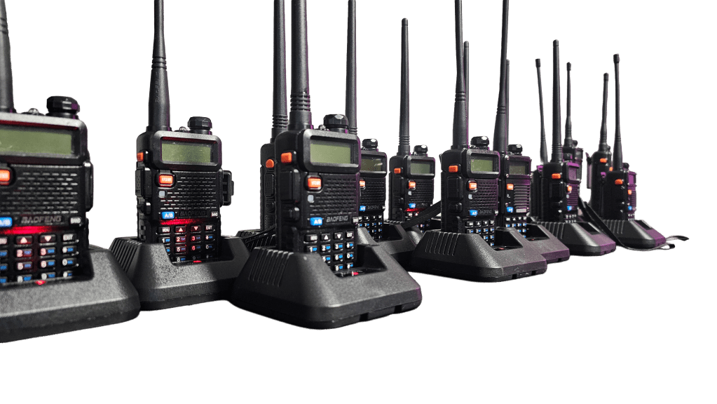 A set of black two-way-radios on charging stands stretched across the image without a background.